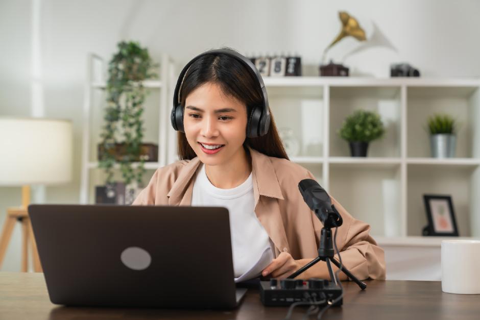 mujer con auriculares y ordenador portátil para transcribir audio a texto