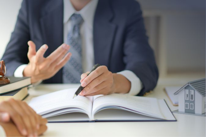 Hombre discutiendo de negocios en una oficina en un escritorio encima de un cuaderno.